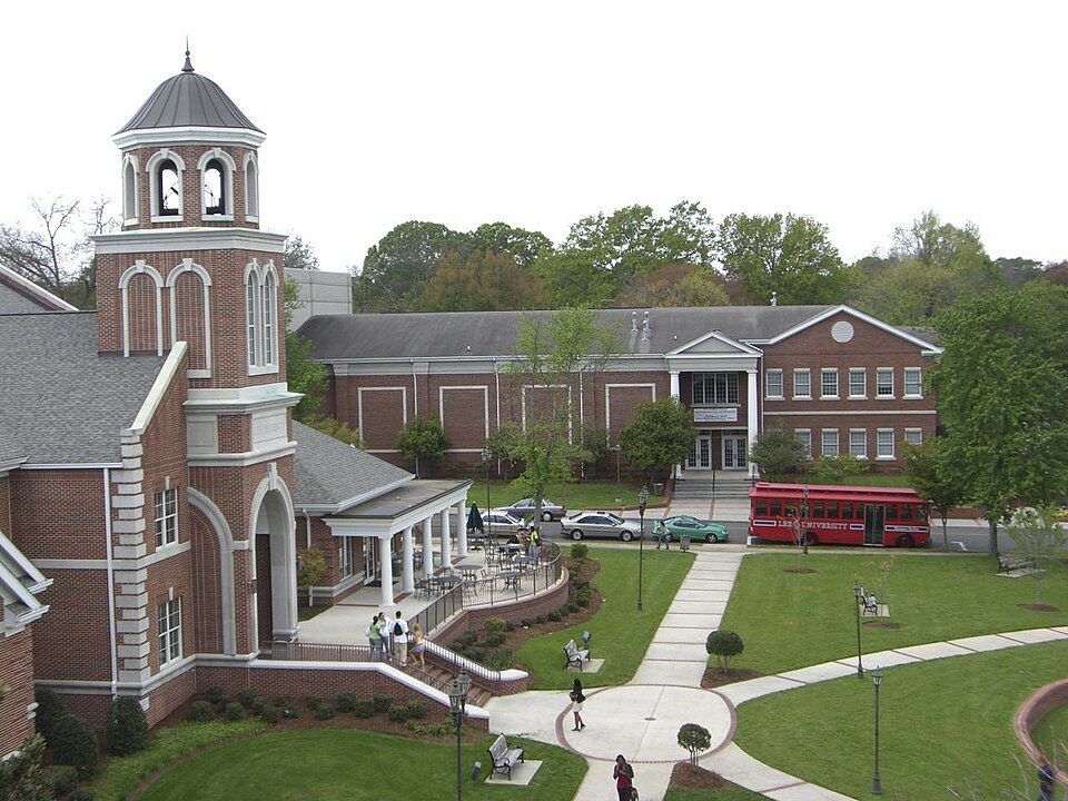 Red-brick buildings, a bell tower and a red trolley on the Lee University campus in Cleveland, Tennessee