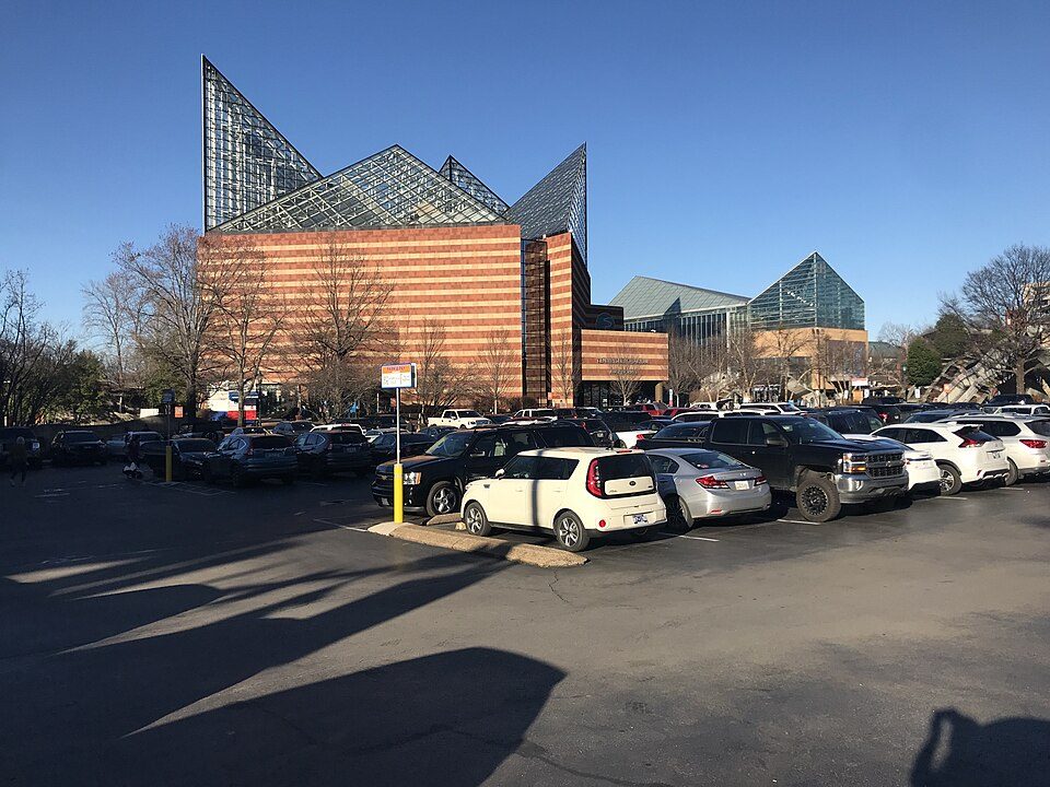 The Tennessee Aquarium's glass-peaked building in downtown Chattanooga, seen across a parking lot