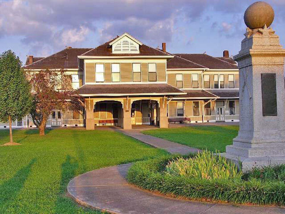 The historic L&N Depot in Etowah, Tennessee, a large yellow-sided railroad depot with a stone monument in the foreground