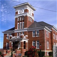Red-brick Monroe County Courthouse with a clock tower in Madisonville, Tennessee
