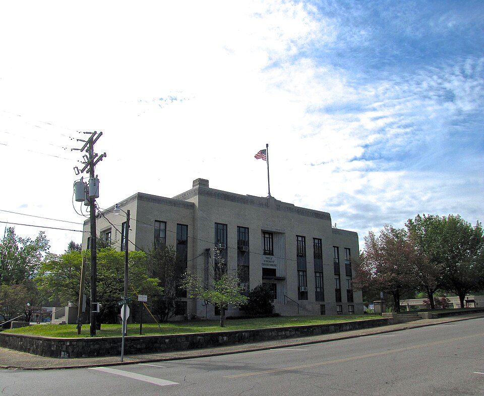 The Polk County Courthouse in Benton, Tennessee, a tan-brick building flying an American flag
