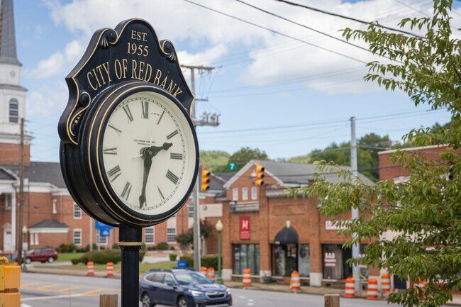 The City of Red Bank clock, established 1955, with downtown brick buildings behind it