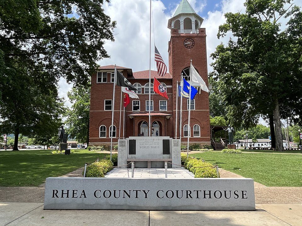 The Rhea County Courthouse in Dayton, Tennessee, with a World War II memorial and flags in front