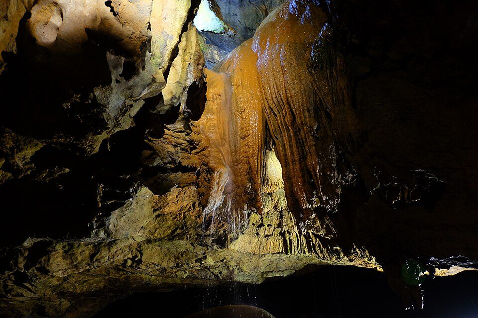 Flowstone and a trickling waterfall inside Tuckaleechee Caverns in Townsend, Tennessee
